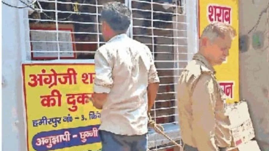 હાથમાં હથકડી, પાછળ પોલીસકર્મી... દુકાન પરથી દારૂ ખરીદતા ગુનેગારનો ફોટો વાયરલ